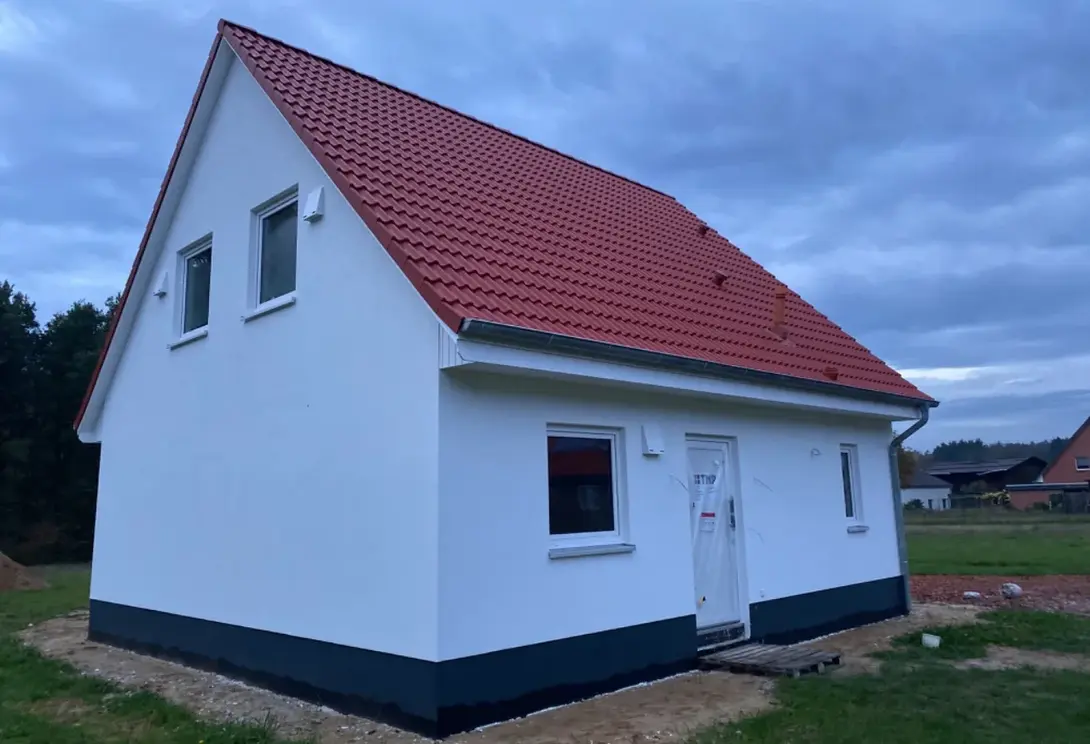 Einfamilienhaus mit rotem Satteldach in Bassum-Neubruchhausen Einfamilienhaus mit weißer Fassade, rotem Satteldach und neu angelegtem Grundstück in Bassum-Neubruchhausen.