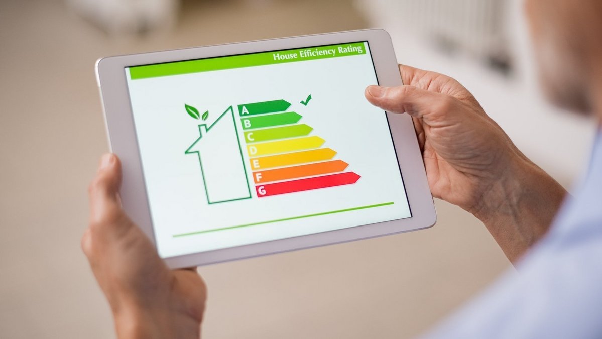 Tablet mit Energieeffizienz-Skala für ein Haus als Symbol für nachhaltiges Bauen, Energieeffizienz und zukunftssicheres Wohnen mit Contura Bau GmbH