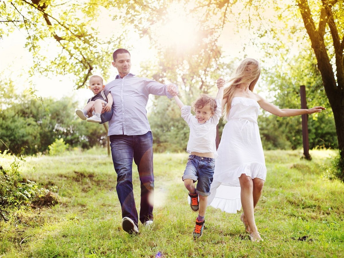 Familie läuft fröhlich durch einen sonnigen Garten