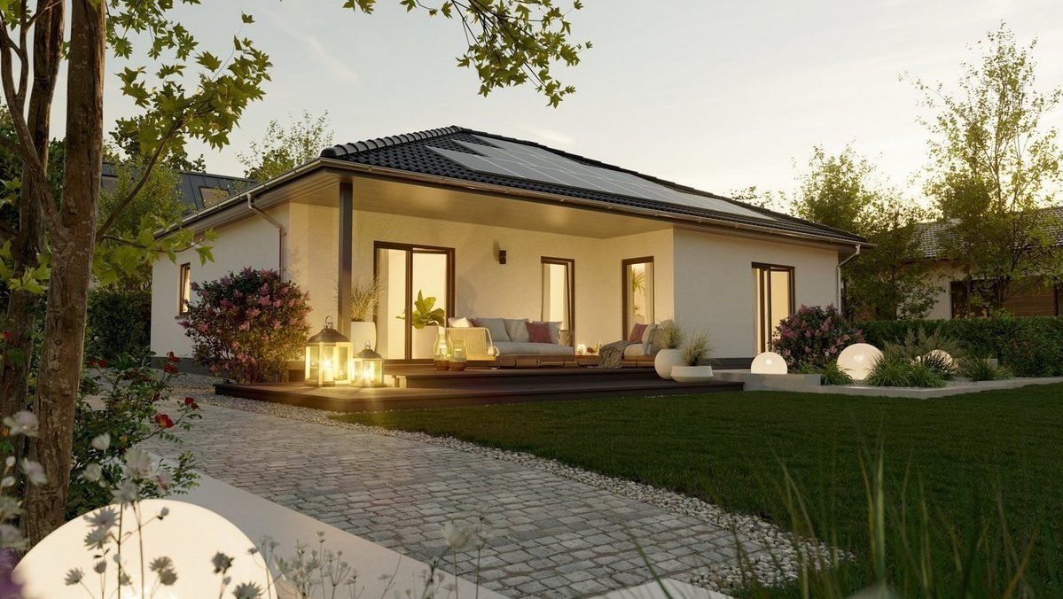 Moderner Bungalow mit Terrasse, Garten und beleuchteter Außenanlage in der Abenddämmerung