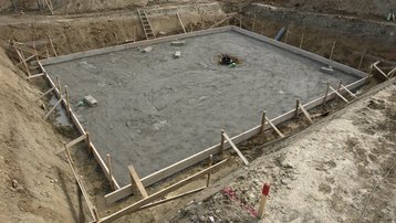 Vom Baugrund zur tragfähigen Bodenplatte Vorbereitete Baugrube mit Fundamentfläche für ein Wohnhaus