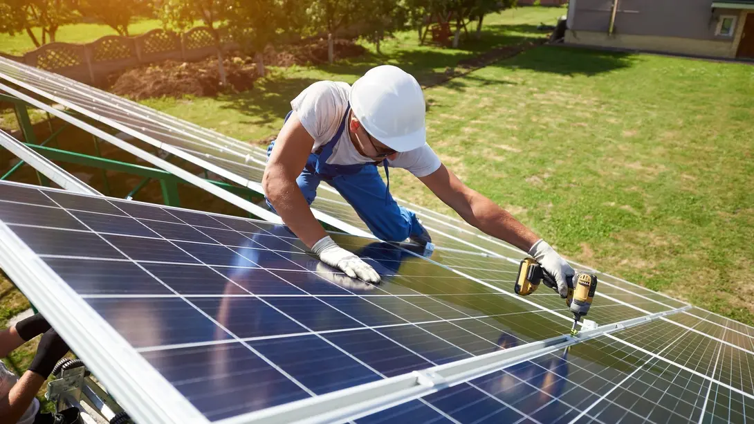 Nachhaltig bauen in Landesbergen mit Photovoltaik Handwerker montiert Photovoltaikmodule auf einem Hausdach in Landesbergen