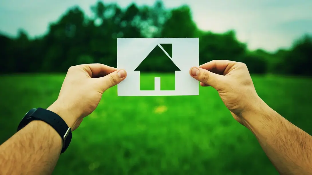 Haus-Symbol auf grüner Fläche als Sinnbild für Grundstückssuche und Hausbau in Nienburg