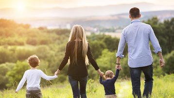 Familie mit zwei Kindern bei einem Spaziergang in der Natur