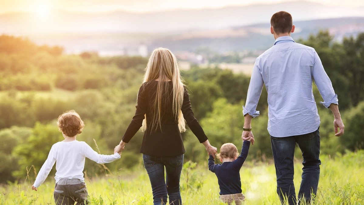Familienfreundlich wohnen in Schwarme Familie geht gemeinsam durch eine grüne Landschaft als Symbol für familienfreundliches Wohnen und Lebensqualität in Schwarme.