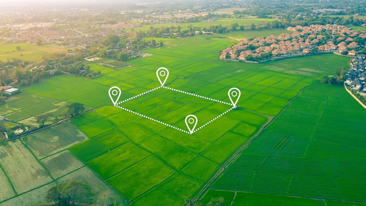 Grundstücksfläche aus der Luft erkennen Luftaufnahme einer Landschaft mit digital markierter Grundstücksfläche nahe eines Wohngebiets