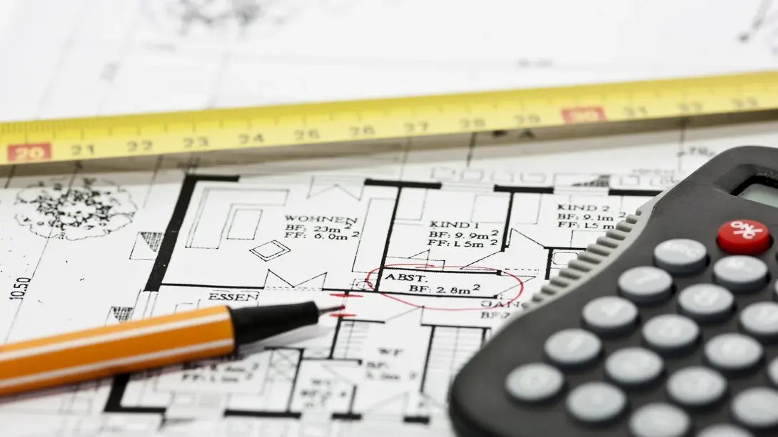 Hausplanung und Grundrissplanung in Diepenau Bauplan mit Maßband, Stift und Taschenrechner als Symbol für Hausplanung, Grundriss und Baukosten in Diepenau.