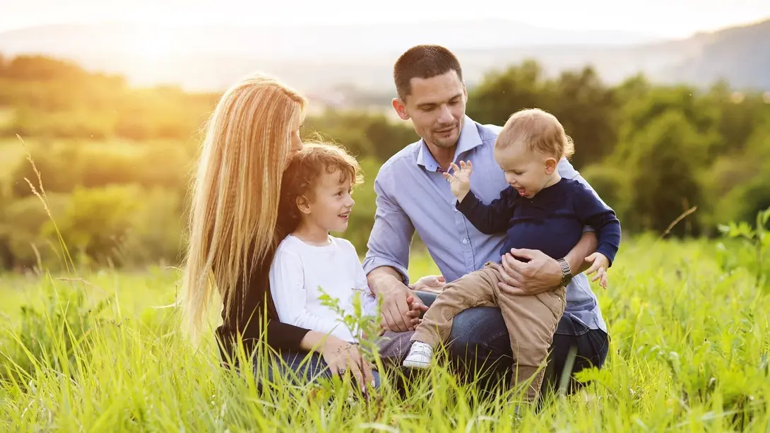 Familienfreundlich wohnen und Haus bauen in Marklohe Familie sitzt in grüner Natur als Symbol für familienfreundliches Wohnen in Marklohe