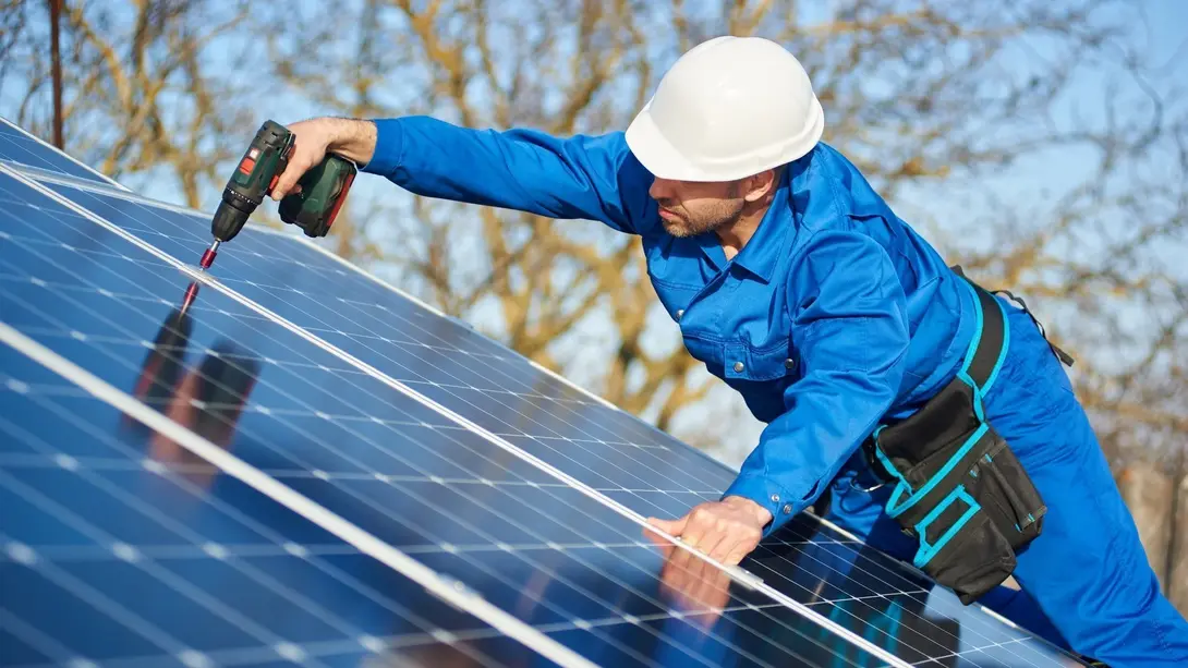 Nachhaltig bauen in Diepenau mit Photovoltaik Handwerker montiert Photovoltaikanlage auf einem Dach für nachhaltiges Bauen in Diepenau