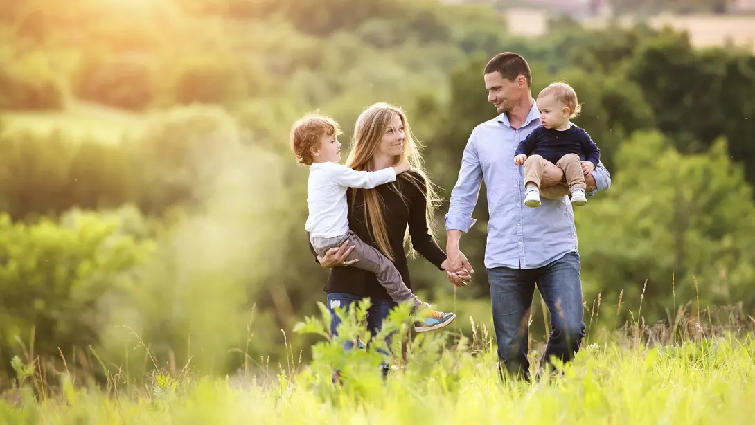Familie spaziert durch grüne Natur als Symbol für familienfreundliches Wohnen in Nienburg
