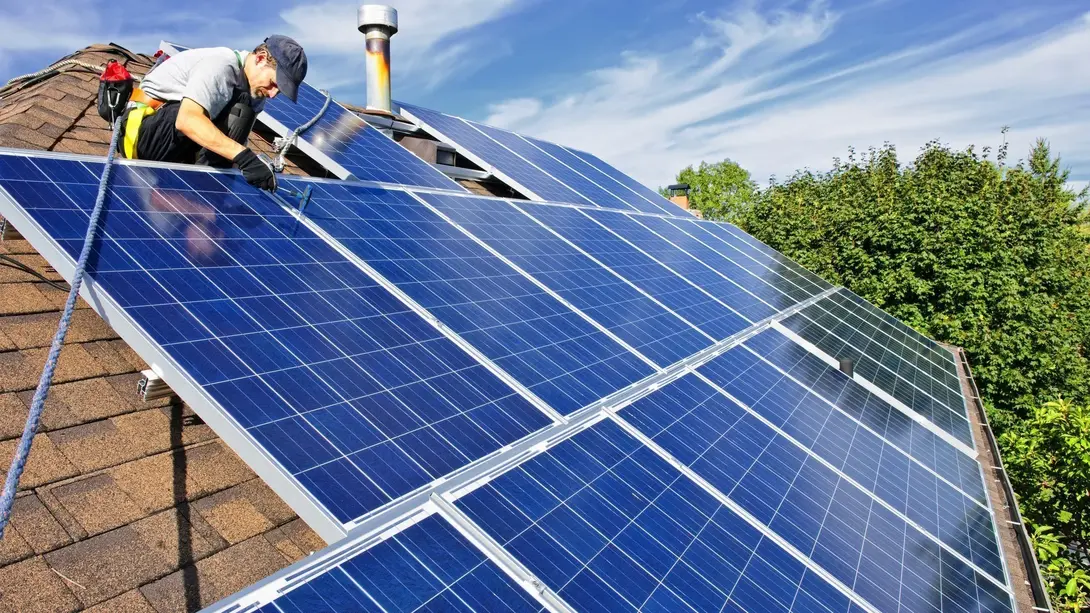 Nachhaltig bauen in Stolzenau mit Photovoltaik Handwerker installiert Photovoltaikanlage auf einem Dach für nachhaltiges Bauen in Stolzenau