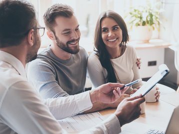 Persönliche Beratung für den Hausbau Bauinteressiertes Paar im Beratungsgespräch mit einem Hausbauberater