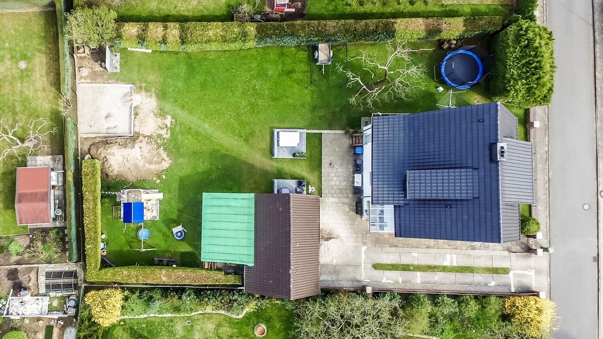 Wohnhaus mit großem Grundstück aus der Vogelperspektive Luftaufnahme eines Wohnhauses mit großem Gartengrundstück, Terrasse, Nebengebäude und angrenzender Straße