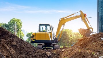 Gelber Kettenbagger bei Erdarbeiten auf einer Baustelle