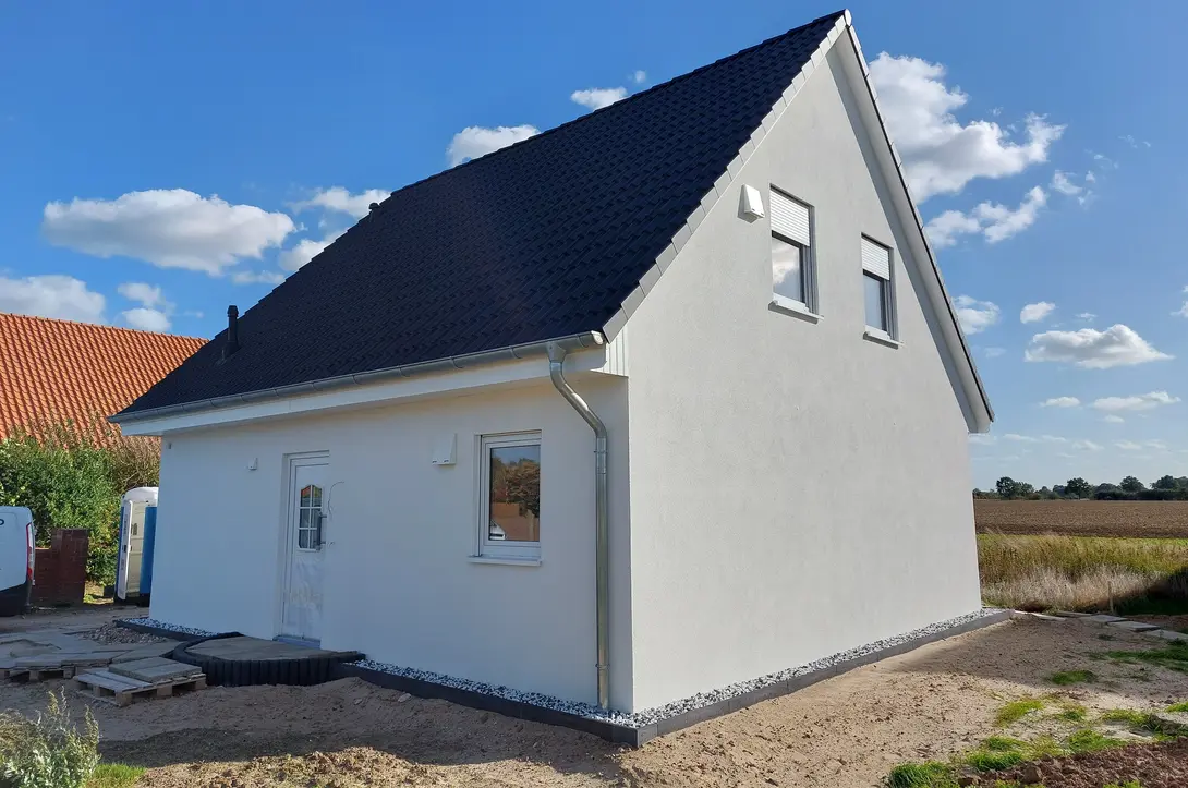 Einfamilienhaus mit Satteldach in ländlicher Lage Einfamilienhaus mit heller Putzfassade, dunklem Satteldach und ländlicher Grundstückslage