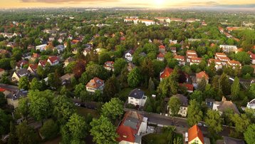 Luftaufnahme eines grünen Wohngebiets bei Sonnenuntergang