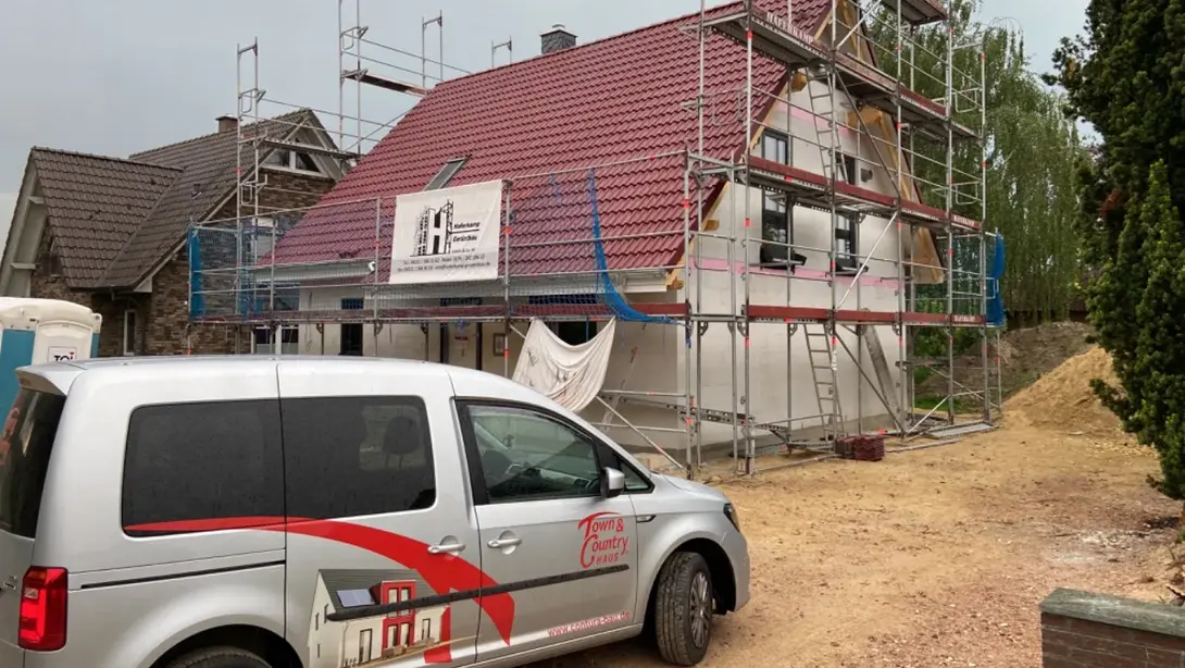 Massivhaus bauen in Marklohe mit Contura Bau GmbH Hausbau in Marklohe mit eingerüstetem Massivhaus und Town & Country Haus Fahrzeug auf der Baustelle
