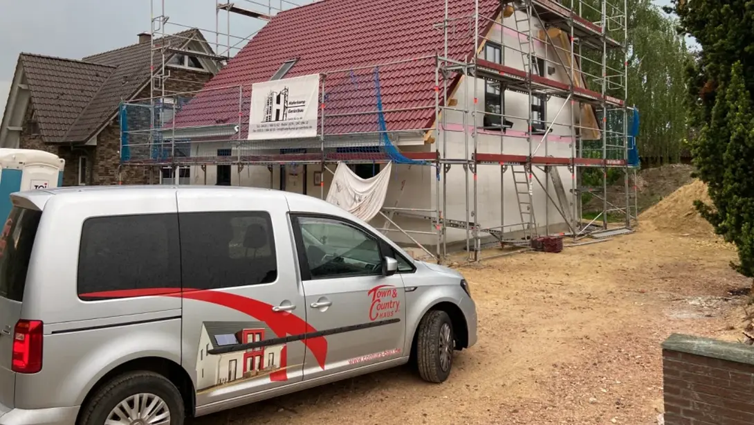 Hausbau-Baustelle mit Town & Country Haus Hausbau-Baustelle mit Gerüst und Town & Country Fahrzeug in Kirchlinteln