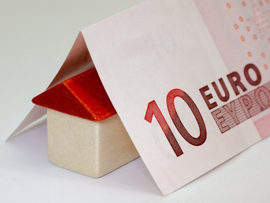 Günstig bauen und Finanzierung planen Hausmodell unter einem 10-Euro-Schein als Symbol für günstige Grundstückspreise, Hausbaukosten und Finanzierung in Leese mit Contura Bau GmbH