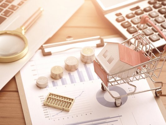 Hausbaukosten und Finanzierung im Überblick Hausmodell, Schlüssel, Münzen, Taschenrechner und Einkaufswagen als Symbol für Hausbaukosten, Finanzierung und Budgetplanung mit Contura Bau GmbH
