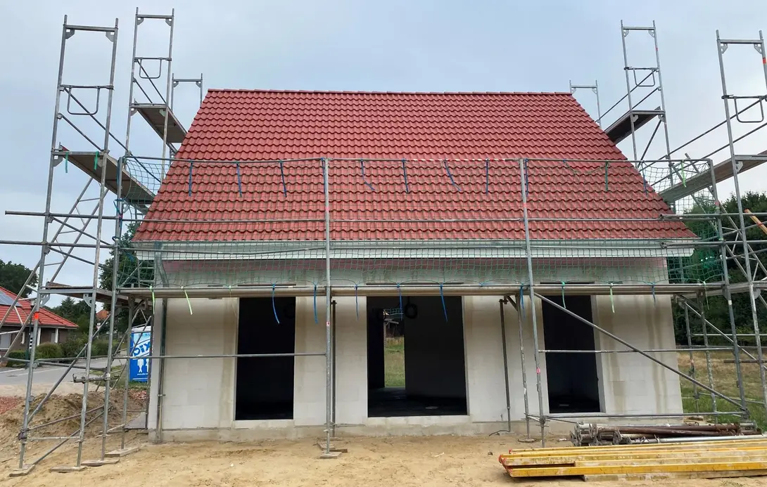 Massivhaus in Steyerberg bauen mit Contura Bau GmbH Hausbau in Steyerberg mit Rohbau, rotem Satteldach und Baugerüst