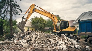 Bagger bei Abbrucharbeiten an einem Gebäude