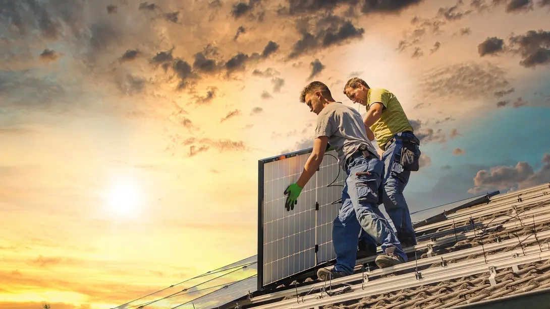 Nachhaltig bauen in Marklohe mit Photovoltaik und Contura Bau GmbH Handwerker installieren Photovoltaikmodule auf einem Hausdach für nachhaltiges Bauen in Marklohe
